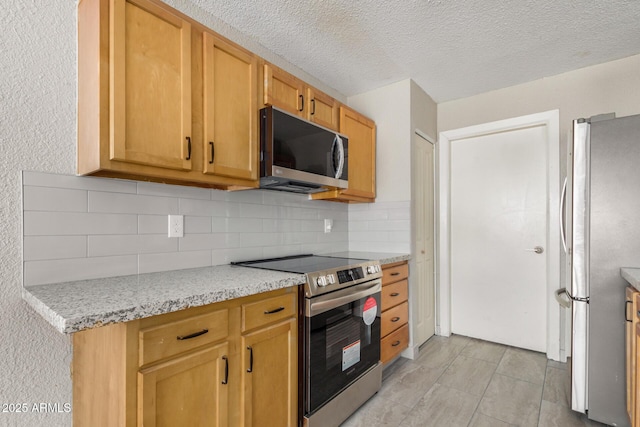 7506 W Sells Dr, Phoenix, AZ 85033 - kitchen with appliances with stainless steel finishes, backsplash, and a textured ceiling