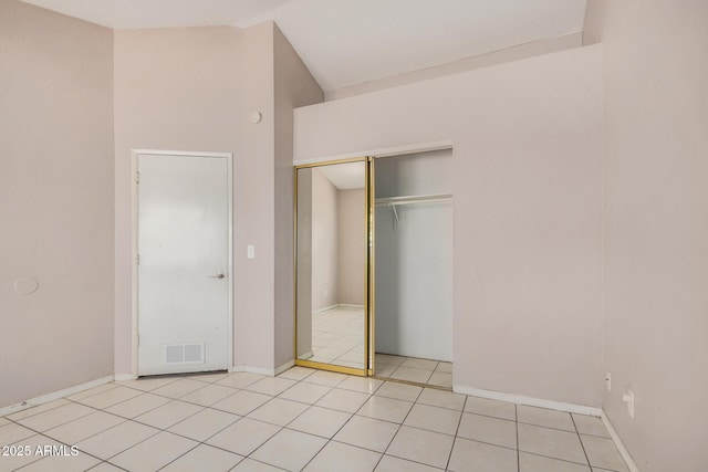 7506 W Sells Dr, Phoenix, AZ 85033 - unfurnished bedroom featuring a closet, vaulted ceiling, light tile patterned flooring, and baseboards