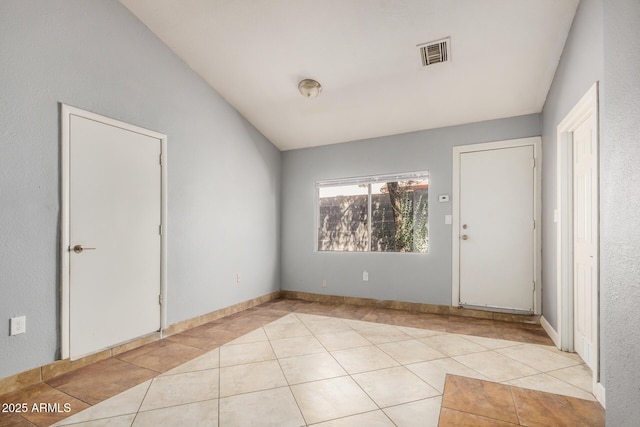 7506 W Sells Dr, Phoenix, AZ 85033 - spare room with light tile patterned floors, baseboards, and vaulted ceiling