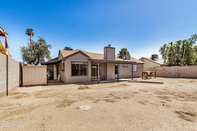 7506 W Sells Dr, Phoenix, AZ 85033 - back of house featuring a chimney, a fenced backyard, and a patio area