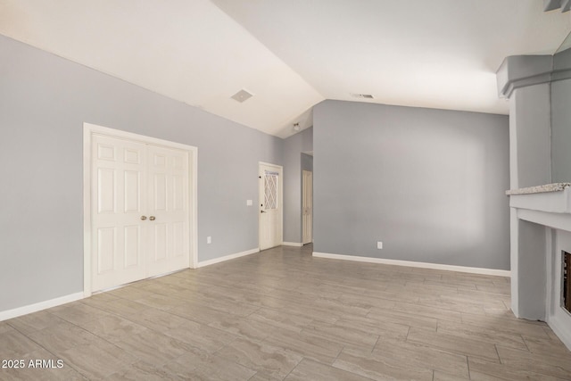 7506 W Sells Dr, Phoenix, AZ 85033 - unfurnished living room featuring vaulted ceiling, a fireplace, baseboards, and wood finished floors