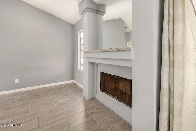7506 W Sells Dr, Phoenix, AZ 85033 - unfurnished living room with vaulted ceiling, a fireplace, baseboards, and wood finished floors