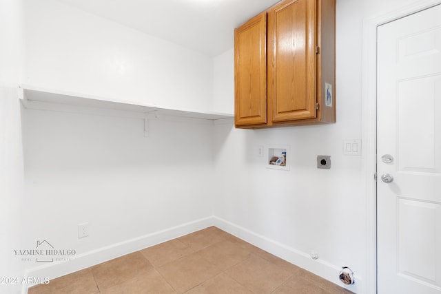 clothes washing area with electric dryer hookup, cabinets, gas dryer hookup, washer hookup, and light tile patterned flooring