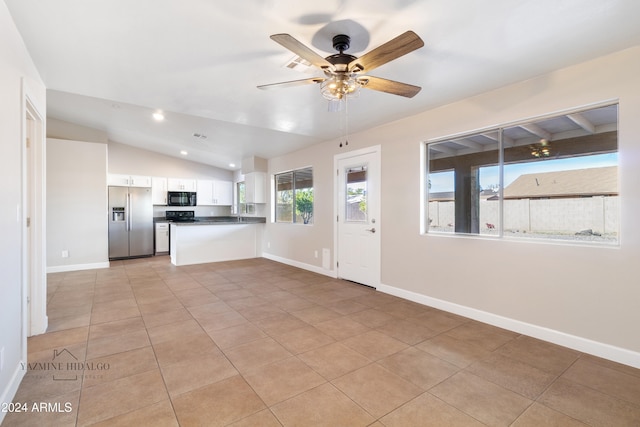 kitchen with lofted ceiling, white cabinets, ceiling fan, kitchen peninsula, and stainless steel appliances