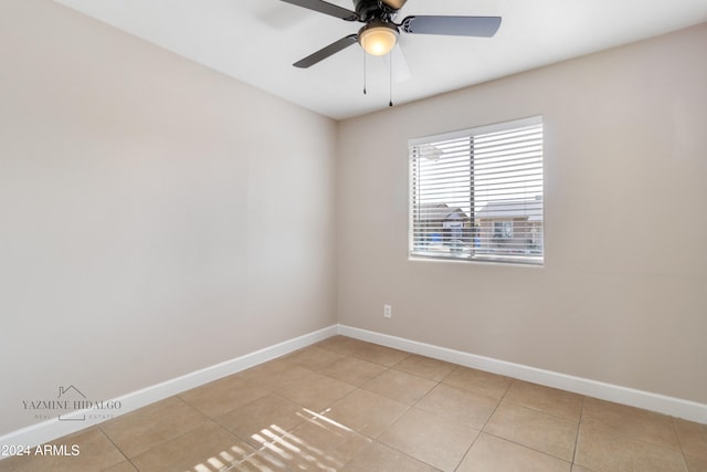 tiled spare room featuring ceiling fan