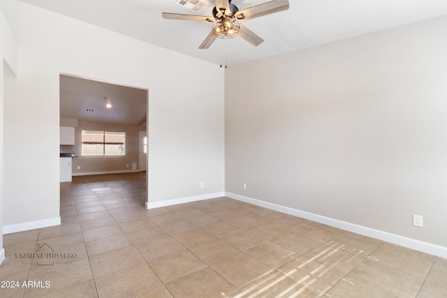 empty room featuring ceiling fan, lofted ceiling, and light tile patterned flooring