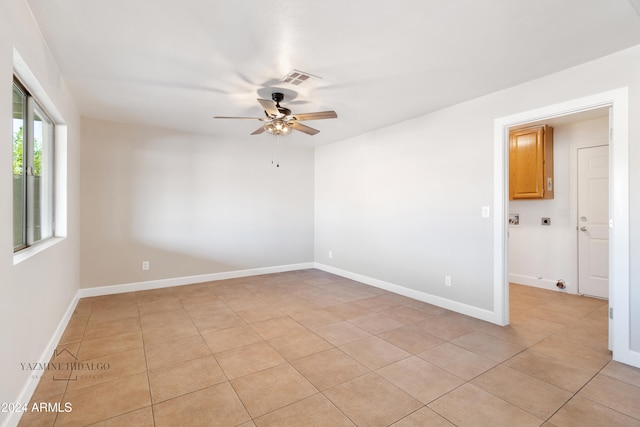 tiled empty room featuring ceiling fan