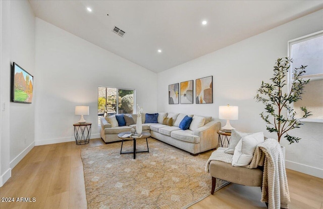 living room featuring light hardwood / wood-style flooring and high vaulted ceiling