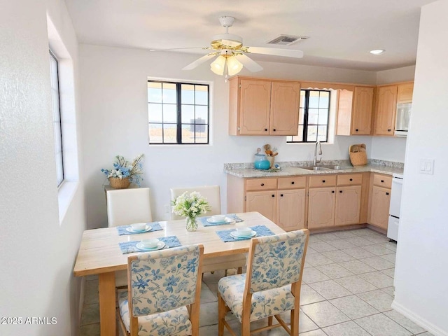 kitchen featuring ceiling fan, sink, light brown cabinets, light tile patterned floors, and range