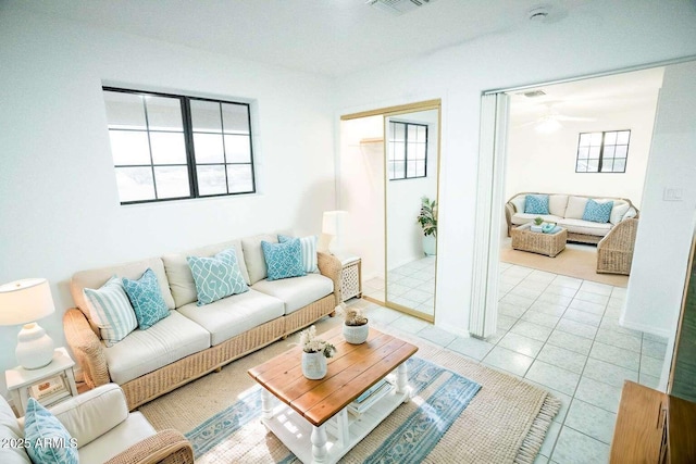 tiled living room with ceiling fan and a healthy amount of sunlight