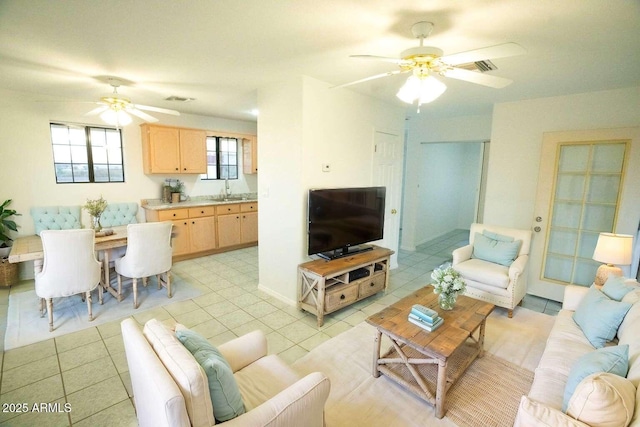 tiled living room with ceiling fan and sink