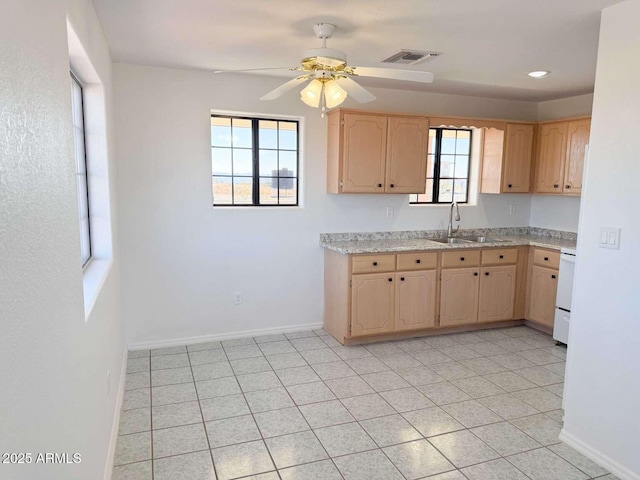 kitchen featuring ceiling fan, sink, stove, and light brown cabinets