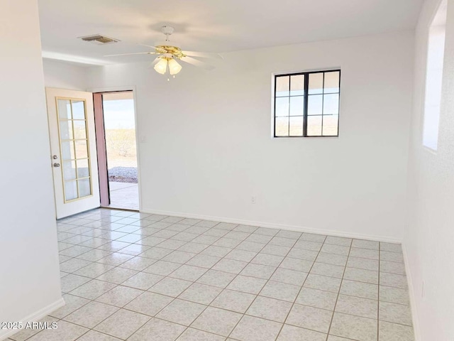 spare room with ceiling fan, light tile patterned floors, and a wealth of natural light