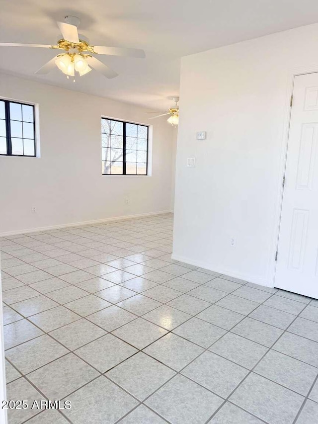 tiled spare room featuring a wealth of natural light and ceiling fan