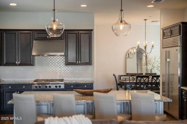 kitchen featuring pendant lighting, a kitchen island, extractor fan, and a breakfast bar area