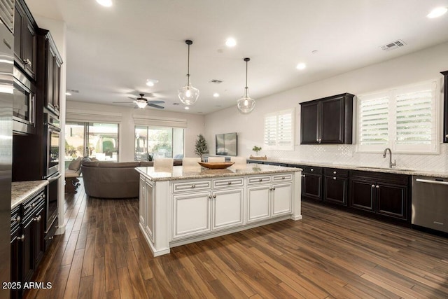 kitchen with white cabinetry, sink, stainless steel appliances, and a kitchen island
