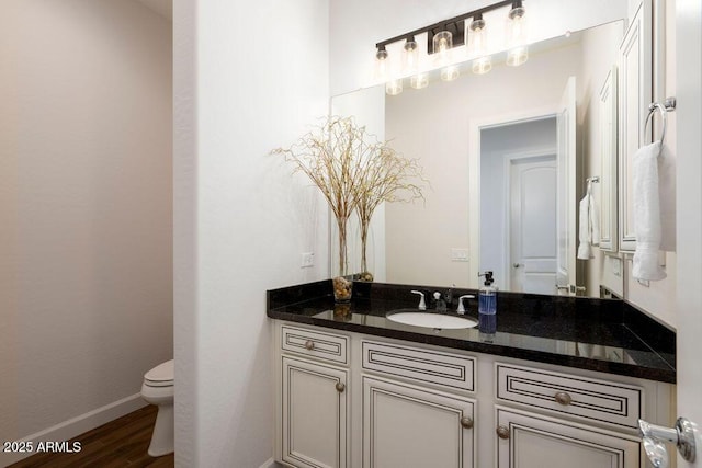 bathroom with hardwood / wood-style flooring, vanity, and toilet