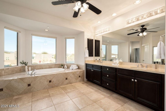 bathroom featuring tile patterned flooring, vanity, and a relaxing tiled tub