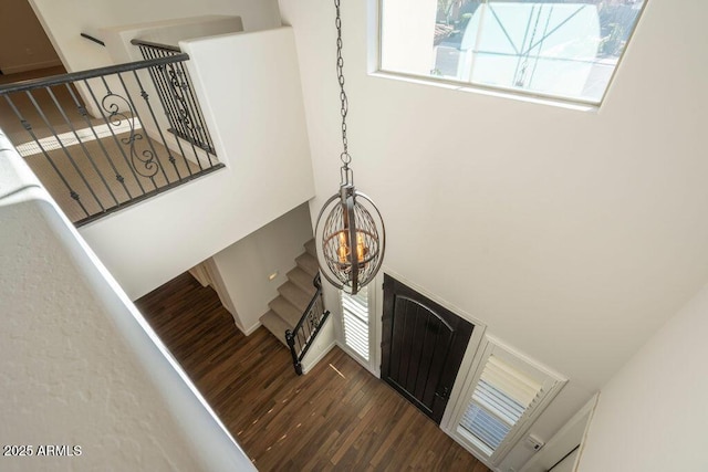 staircase featuring a notable chandelier and wood-type flooring