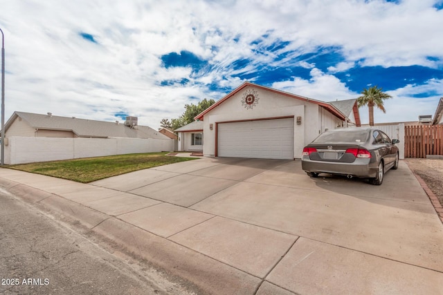 view of front facade with an attached garage, fence, concrete driveway, stucco siding, and a front lawn