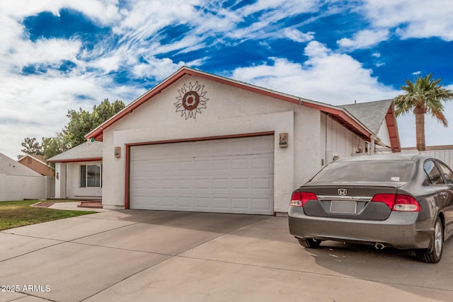 view of front of house featuring a garage, driveway, and stucco siding