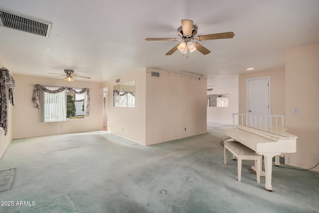 unfurnished living room featuring ceiling fan and carpet floors