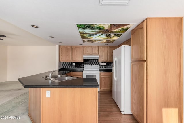 kitchen featuring white appliances, a sink, dark countertops, under cabinet range hood, and backsplash