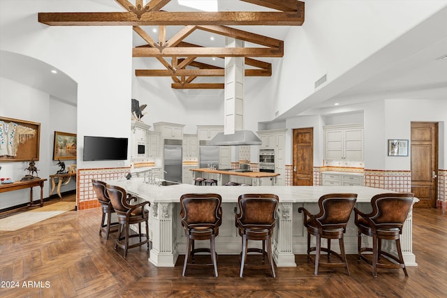 kitchen with a large island, dark parquet floors, and a breakfast bar