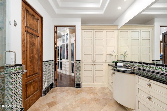 bathroom with vanity, a raised ceiling, and tile floors