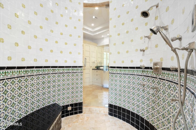 bathroom featuring tile flooring, tile walls, and a tray ceiling