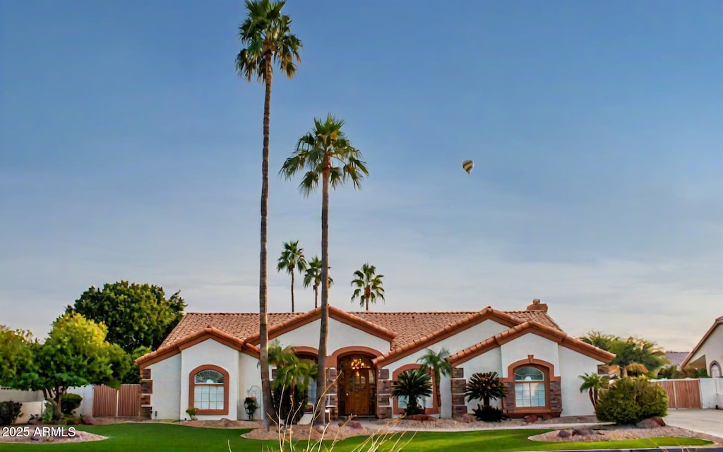 mediterranean / spanish-style home with a front lawn