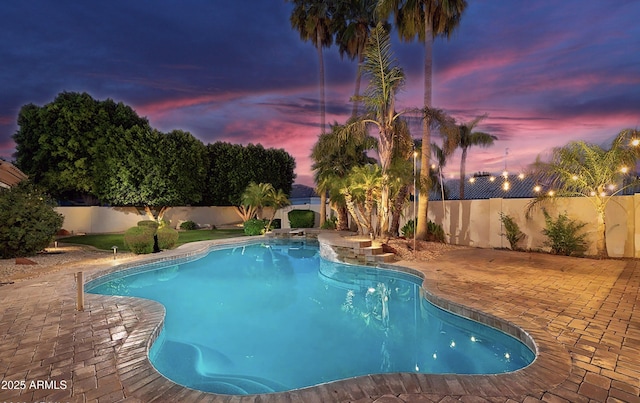 pool at dusk with a patio