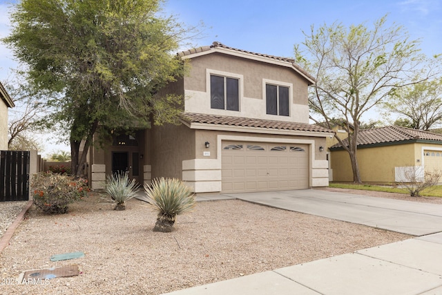 view of front of home with fence, driveway, stucco siding, a garage, and a tile roof