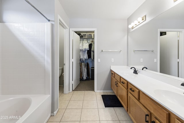 full bathroom with a sink, baseboards, double vanity, and tile patterned flooring