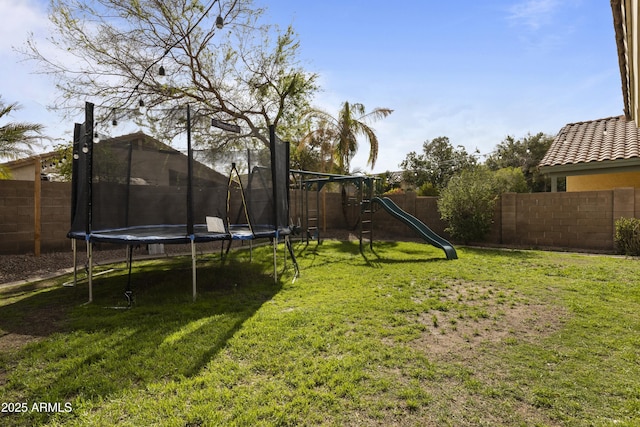 view of yard featuring a trampoline and a fenced backyard