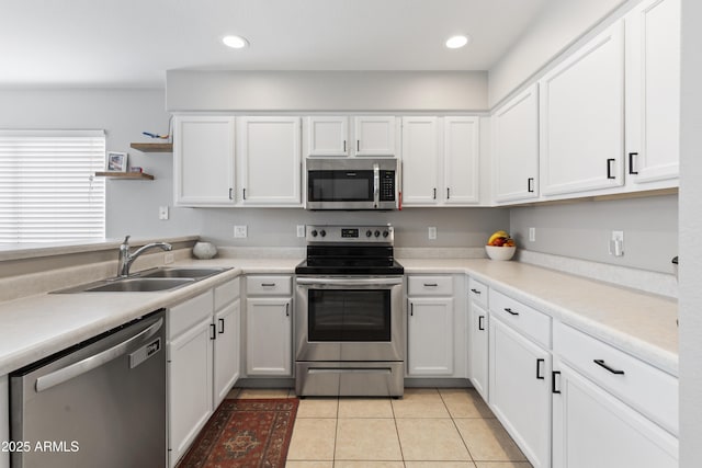 kitchen featuring a sink, light tile patterned floors, stainless steel appliances, white cabinetry, and open shelves