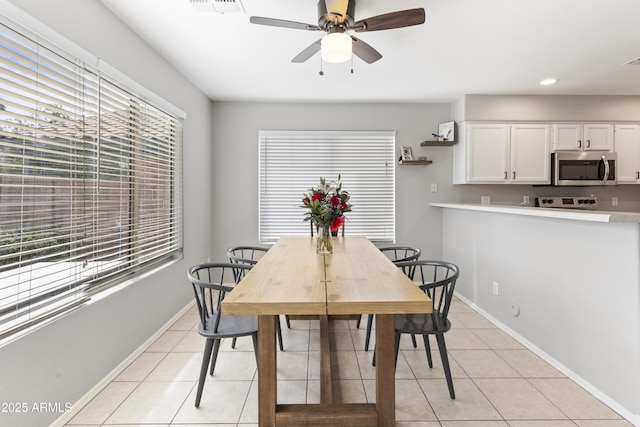 dining room featuring light tile patterned flooring, ceiling fan, and baseboards