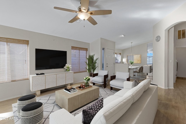 living room with vaulted ceiling, ceiling fan, and light hardwood / wood-style flooring