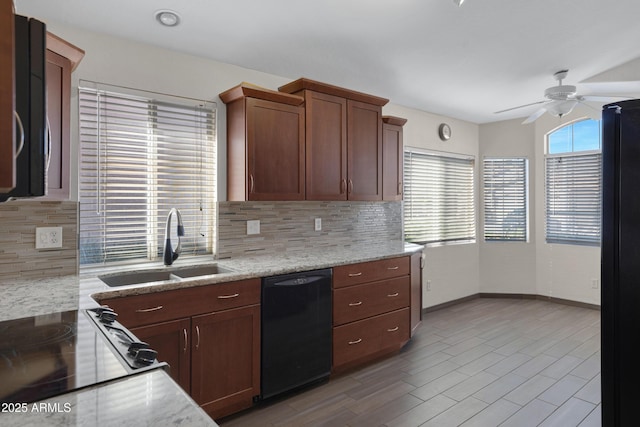 kitchen with light stone countertops, sink, backsplash, and black appliances