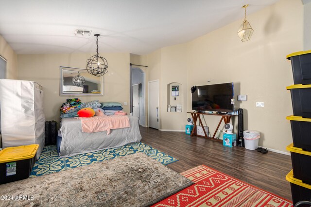 bedroom featuring dark wood-type flooring and an inviting chandelier