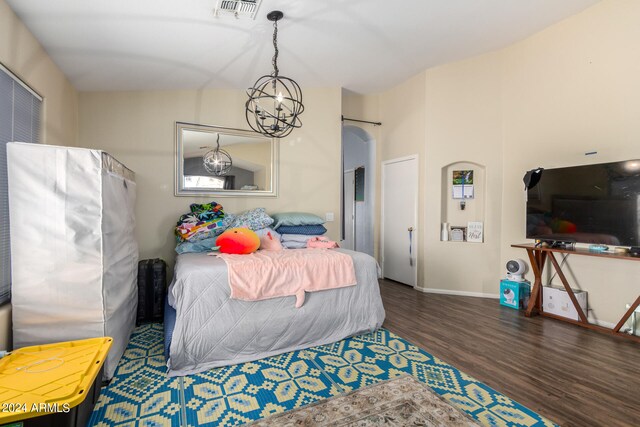 bedroom featuring lofted ceiling, a chandelier, and dark hardwood / wood-style flooring