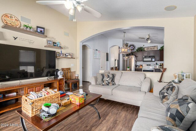 living room featuring ceiling fan with notable chandelier, lofted ceiling, and dark hardwood / wood-style floors