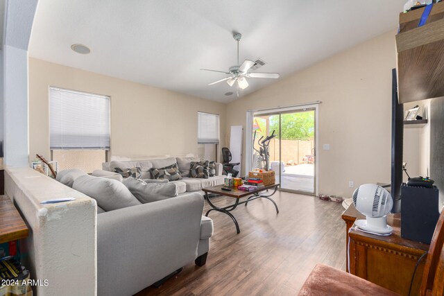 living room with hardwood / wood-style flooring, ceiling fan, and vaulted ceiling