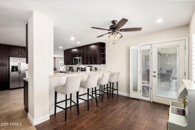 1311 W Ellis St, Mesa, AZ 85201 - kitchen with appliances with stainless steel finishes, a kitchen bar, open shelves, dark brown cabinets, and ceiling fan