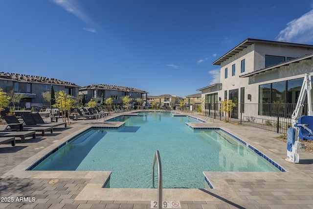 pool with a residential view, a patio area, and fence