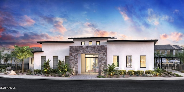 modern home featuring stone siding, fence, and stucco siding