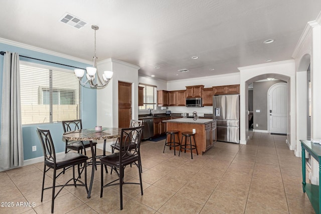 157 N 110th Ave, Avondale, AZ 85323 - dining space featuring arched walkways, a chandelier, light tile patterned floors, ornamental molding, and baseboards