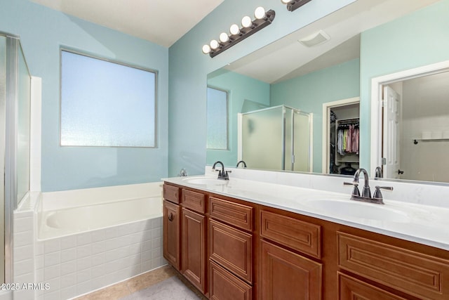 157 N 110th Ave, Avondale, AZ 85323 - full bathroom featuring a stall shower, a bath, double vanity, a spacious closet, and tile patterned floors