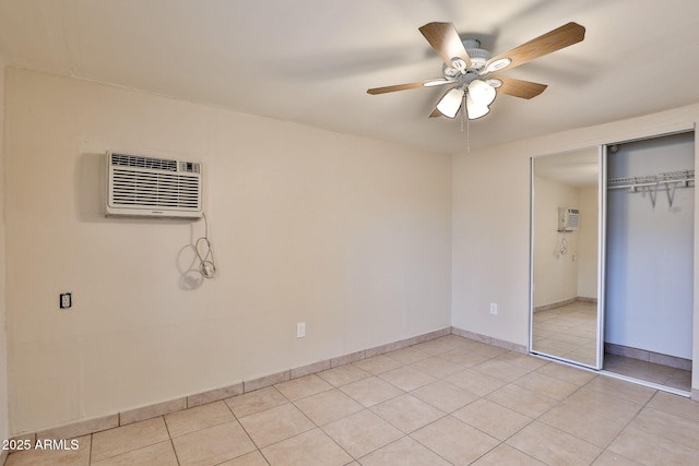 unfurnished bedroom featuring ceiling fan, a closet, a wall mounted AC, and light tile patterned flooring