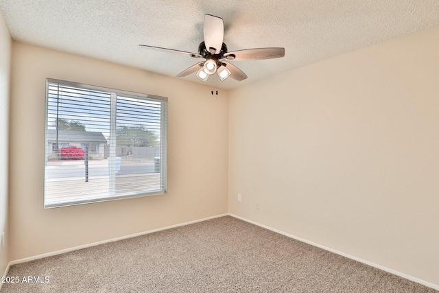 carpeted spare room featuring ceiling fan and a textured ceiling